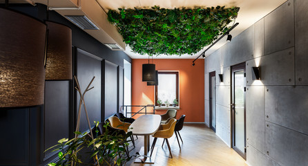 Natural interior in modern cafe with plants on ceiling
