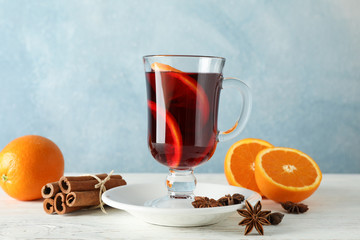 Mulled wine, orange and cinnamon on white wooden background, space for text