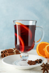 Mulled wine, orange and cinnamon on white wooden background, space for text