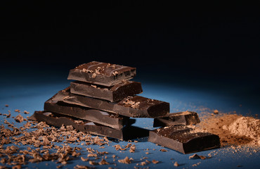 Pieces of dark chocolate, chocolate chips and cocoa powder.