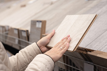 Woman is choosing a new laminate in a construction store.