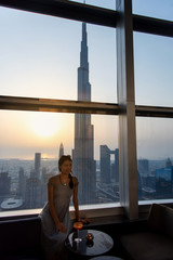 Woman enjoying a drink with downtown Dubai view