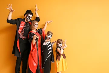 Tuinposter Family in Halloween costumes on color background © Pixel-Shot