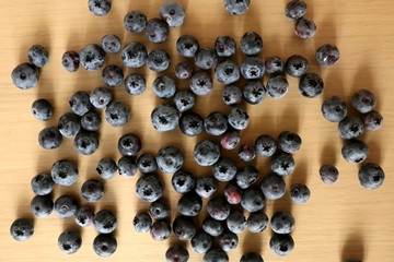 Pile of blueberries on a wooden table. Top view.