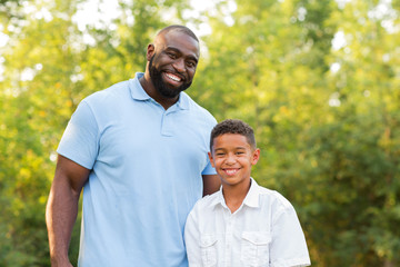 Father and his son laughing and playing at the park.