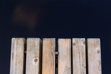 Holzsteg vor dunkelblauem Wasser. Wooden pier and dark blue water.