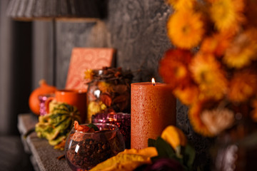 An autumn vintage decorative composition with a candle, pumpkin and dried flowers. Cozy home concept