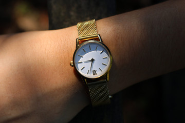 Young girl with a gold watch and quartz on her wrist.
