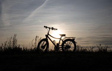 Fototapeta na wymiar bicycle on sunset, Bornholm, silhouette of a bicycle against the backdrop of the setting sun