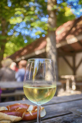Glass of white wine and pretzel at beer garden in Bavaria