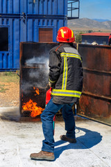 firefighter putting out a fire with a fire extinguisher