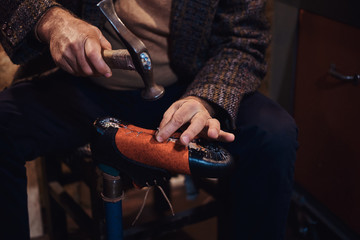 Closeup photoshoot of man making comfortable hand made shoes for people.