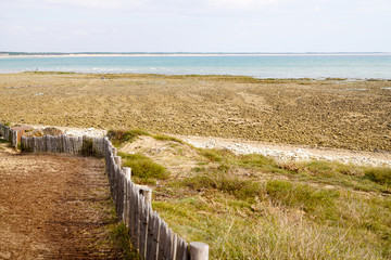 Fototapeta na wymiar Saint Vincent sur Jard beach wooden fence along pedestrian path in Vendee France