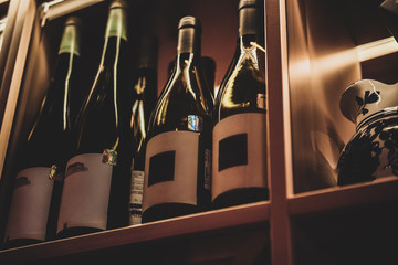 Bottles of tasty wine in posh reastoraunt are stored on the shelf.