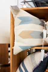 Assorted throw pillows in wooden shelf at store
