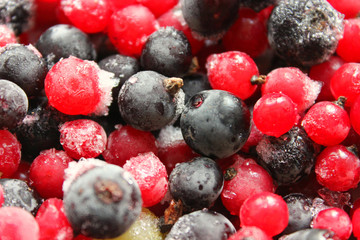 Different kinds of frozen berries, background, close-up. Red currant, black currant, gooseberries covered with frost, harvesting for the winter of fresh summer berries.