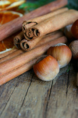 Christmas decor. Christmas spices. Cinnamon sticks, anise stars, walnuts, hazelnuts, dried orange on an old wooden background, copy space.