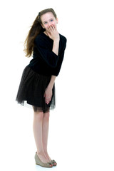 Fototapeta premium A beautiful little girl stands in the wind, her hair and clothes