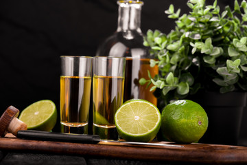 Mexican Gold Tequila with lime and salt on black background with copyspace.