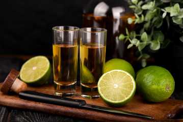 Mexican Gold Tequila with lime and salt on black background with copyspace.