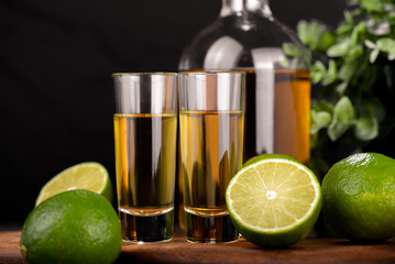 Mexican Gold Tequila with lime and salt on black background with copyspace.