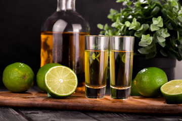 Mexican Gold Tequila with lime and salt on black background with copyspace.