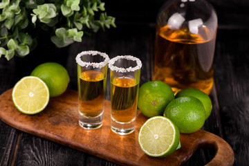 Mexican Gold Tequila with lime and salt on black background with copyspace.