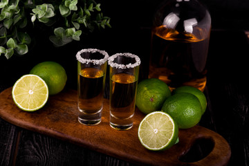 Mexican Gold Tequila with lime and salt on black background with copyspace.