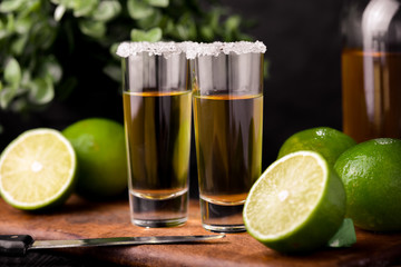 Mexican Gold Tequila with lime and salt on black background with copyspace.