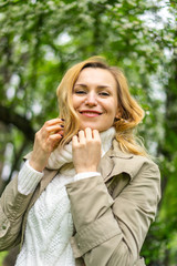 Beautiful blond woman posing outdoors at the blur spring park of violet and white lilac background