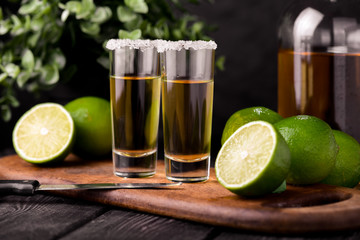 Mexican Gold Tequila with lime and salt on black background with copyspace.