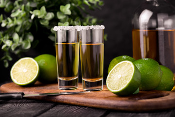 Mexican Gold Tequila with lime and salt on black background with copyspace.