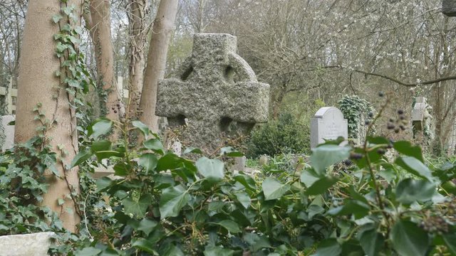 An old stone cross in a cemetery.