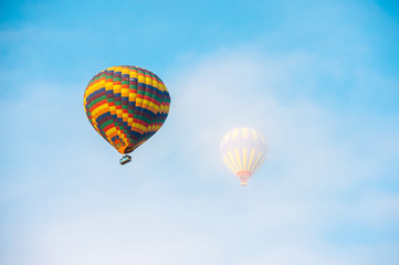 Many colorful hot air balloons flight above mountains - panorama of Cappadocia at sunrise. Wide landscape of Goreme valley in Cappadocia - billboard background for your travel concept in Turkey.