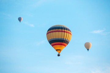 Many colorful hot air balloons flight above mountains - panorama of Cappadocia at sunrise. Wide landscape of Goreme valley in Cappadocia - billboard background for your travel concept in Turkey.