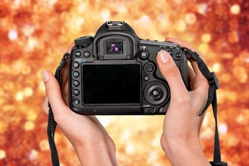 Hands holding modern camera isolated on white background