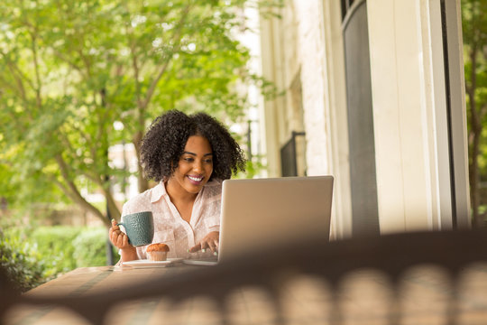 African American woman working and drinking coffee.