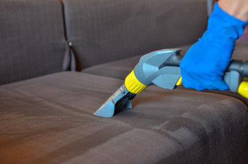 Cleaning sofa with vacuum cleaner
