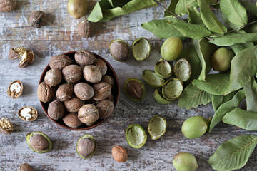 Freshly walnuts in a bowl. Harvest walnuts. Walnuts peeled from green shells. The leaves of the walnut tree.