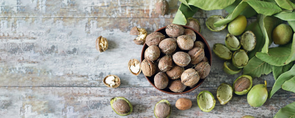 Freshly walnuts in a bowl. Harvest walnuts. Walnuts peeled from green shells. The leaves of the walnut tree.
