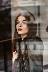 Portrait of beautiful woman, captured through the window glass
