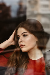 Portrait of beautiful woman, captured through the window glass