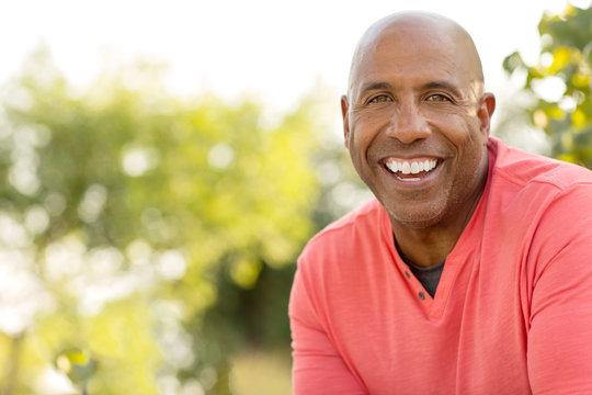 Mature handsome African American man smiling outside.