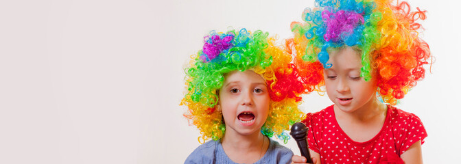Funny image of cute child girls superstars singing with the microphone. Free space for text.