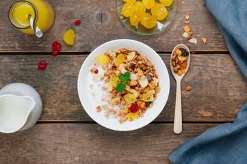 Granola with chocolate and dried citrus in the bowl on wooden background
