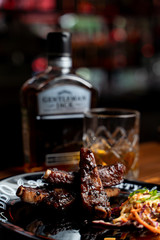 glass of wine and bottle of red wine on wooden table