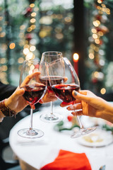 hands clinking glasses of christmas. Celebration. Hands holding the glasses wine making a toast.