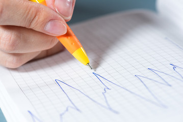 Stock trader draws a stock price chart close up background.