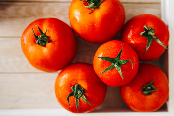 Fresh, pink and red tomatoes on white, different backgrounds and in a wooden crate