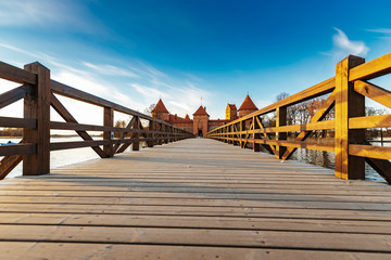 Fototapeta premium Wooden bridge to the Trakai castle in Lithuania during sunset. One of the most popular tourism objects in Lithuania.